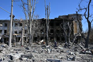 Workers repair wires in front of a heavily damaged children's clinic following recent shelling, which local Russian-installed officials called a Ukrainian military strike, in Donetsk, Russian-controlled Ukraine